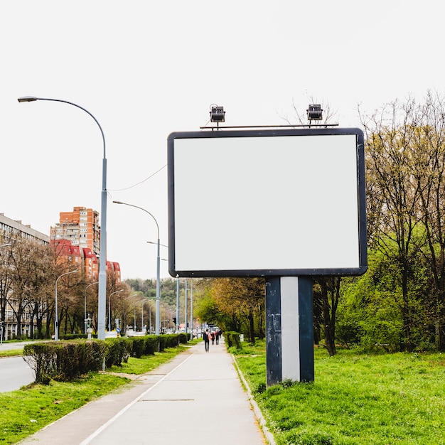 Photo gratuite panneau d'affichage avec deux lampes près du trottoir de la ville