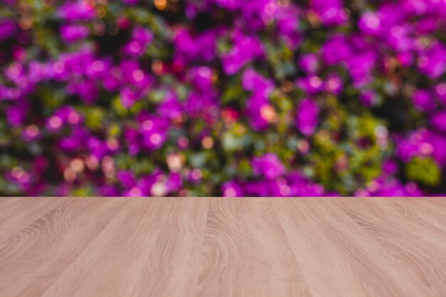 Panneau de bois table vide avec des fleurs floues en arrière-plan