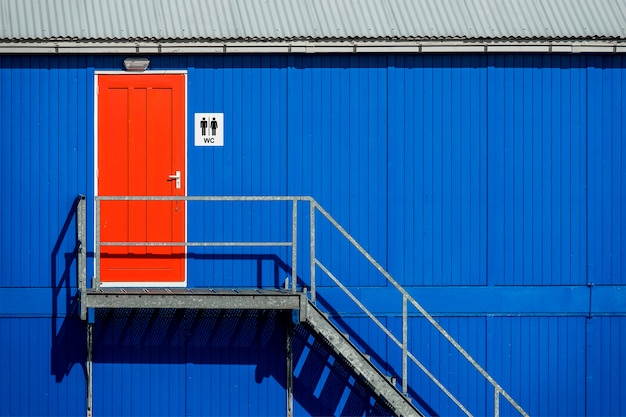 Panneau de salle de bain près de la porte rouge