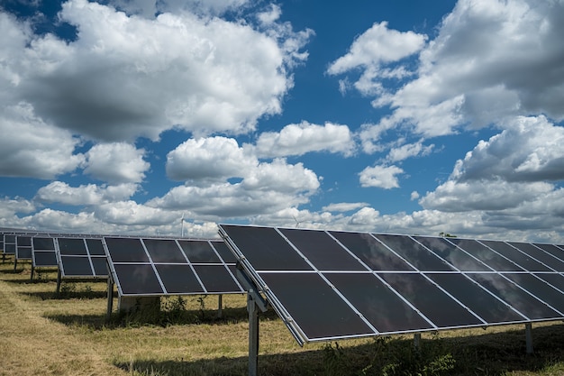 Photo gratuite panneaux solaires utilisés pour l'énergie renouvelable sur le terrain sous le ciel plein de nuages