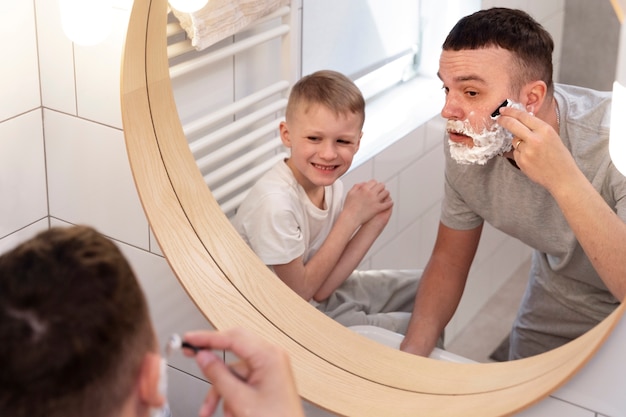 Photo gratuite papa apprend à son fils à se raser