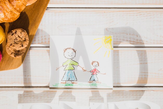 Papa écrit l&#39;ombre sur le dessin et la pâtisserie