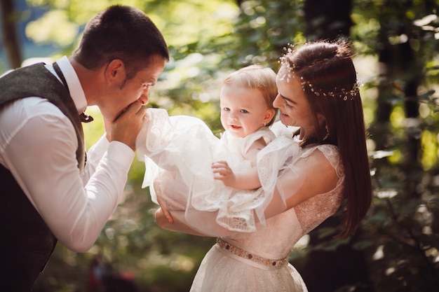 Papa embrasse son pied de petite fille pendant que sa mère la tient