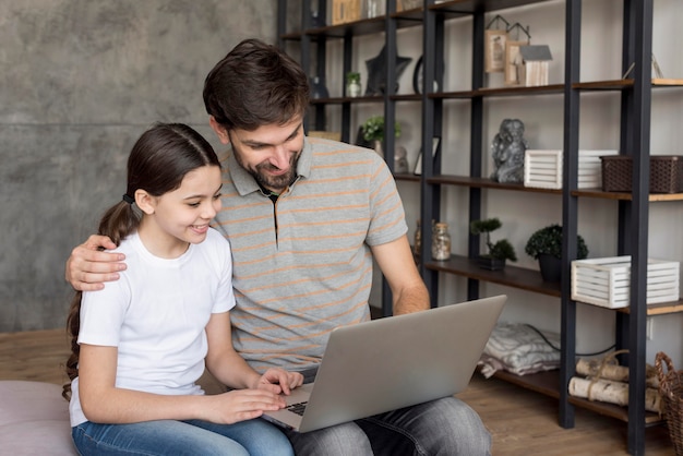 Papa enseigne à une fille d'utiliser un ordinateur portable