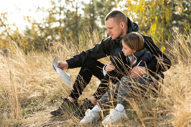 Papa et petite fille lisant une carte dans la nature