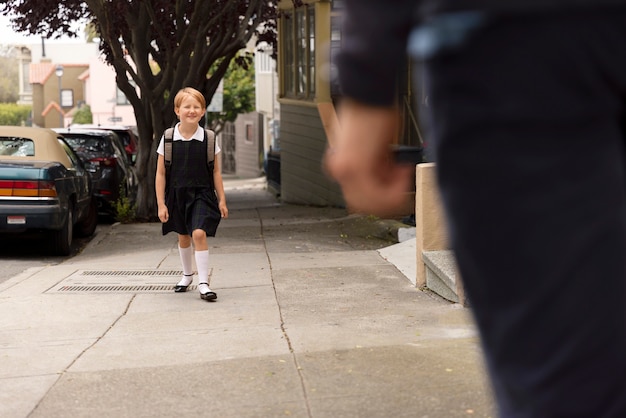 Papa promène les enfants pour le premier jour d'école