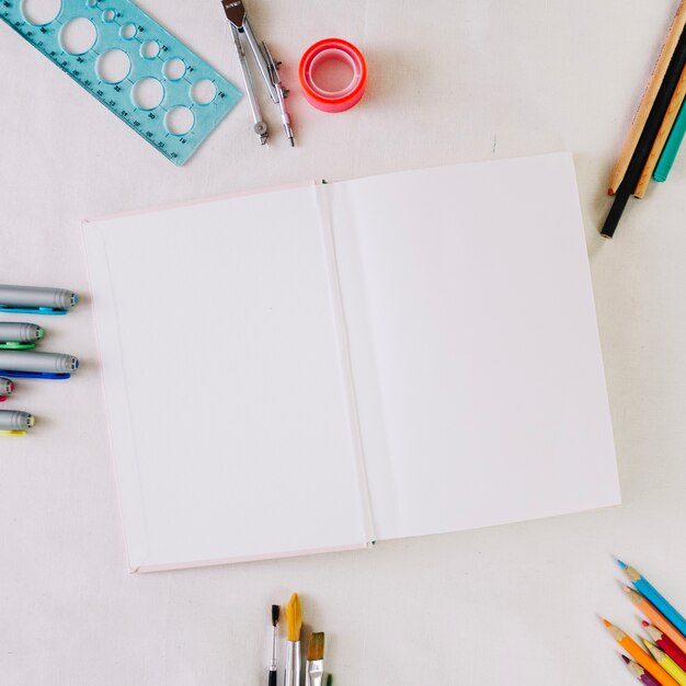 Papeterie autour de cahier avec des pages blanches