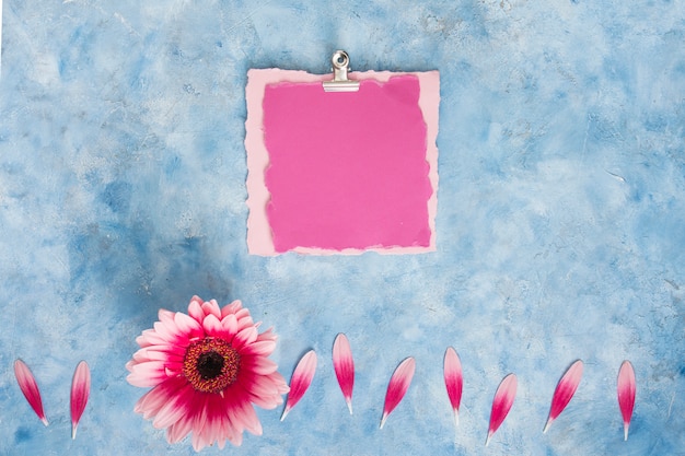 Photo gratuite papier blanc avec fleur de gerbera sur table