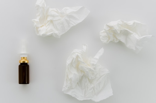 Photo gratuite papier blanc froissé et bouteille compte-gouttes sur fond blanc