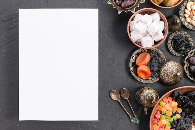 Papier blanc vierge avec des bonbons arabes; fruits secs; noix pour le ramadan sur fond noir