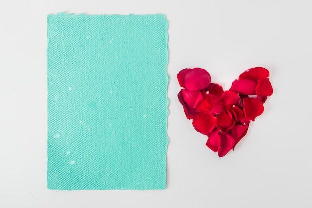 Papier bleu près des pétales en forme de coeur