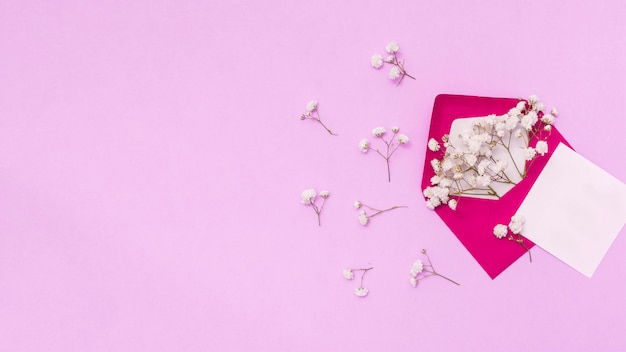 Papier avec enveloppe et branches de fleurs sur la table