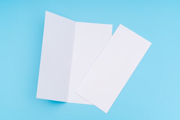 Papier modèle blanc bifold sur fond bleu.