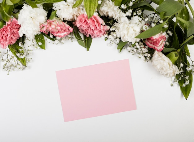 Papier vide rose et bouquet de fleurs