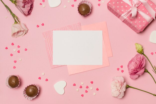 Papiers entre symboles de coeurs, bonbons, cadeaux et fleurs