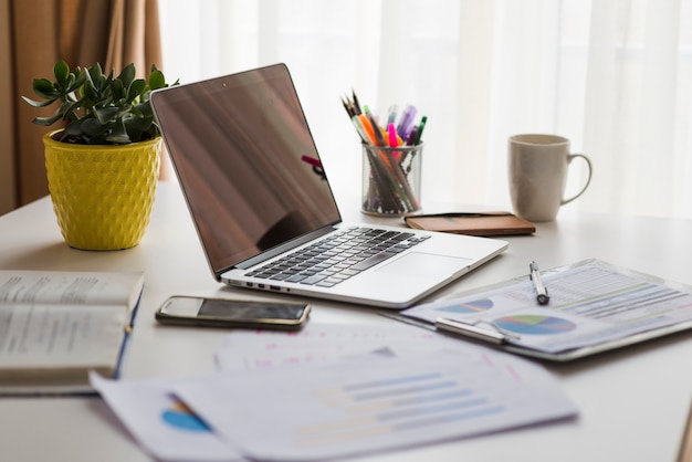 Papiers et ordinateur portable sur la table de bureau