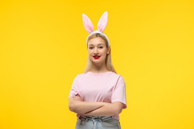 Pâques belle blonde adorable fille avec des oreilles de lapin rose et rouge à lèvres avec les mains croisées