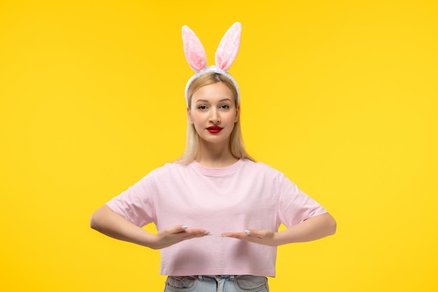 Photo gratuite pâques belle blonde adorable fille avec des oreilles de lapin rose et rouge à lèvres tenant les mains vers le bas