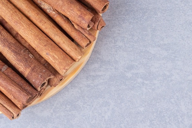 Paquet de bâtons de cannelle sur un petit plateau sur table en marbre.