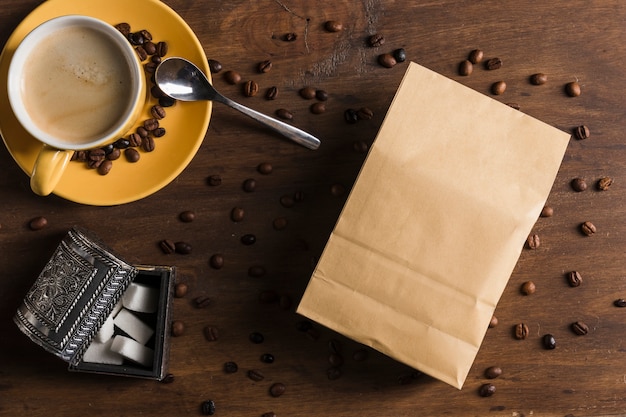 Photo gratuite paquet près tasse jaune et sucrier