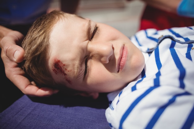 Photo gratuite les paramédics examinent un garçon blessé