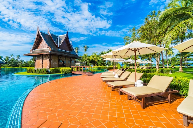 Photo gratuite parasol et chaise autour de la piscine