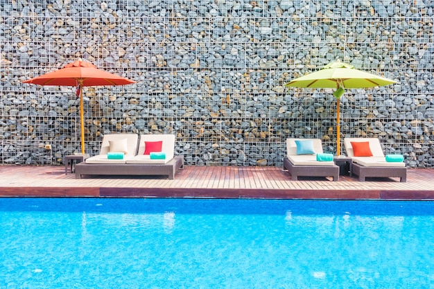 Photo gratuite parasol et chaise autour de la piscine