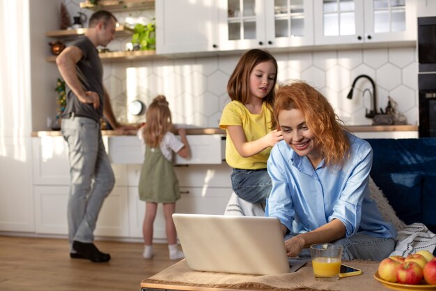 Parent essayant de travailler à domicile entouré d'enfants