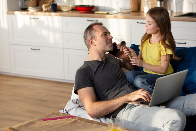 Parent essayant de travailler à domicile entouré d'enfants