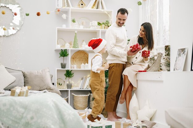 Parent et leur petit fils s'amusant et jouant ensemble à l'intérieur au moment de Noël