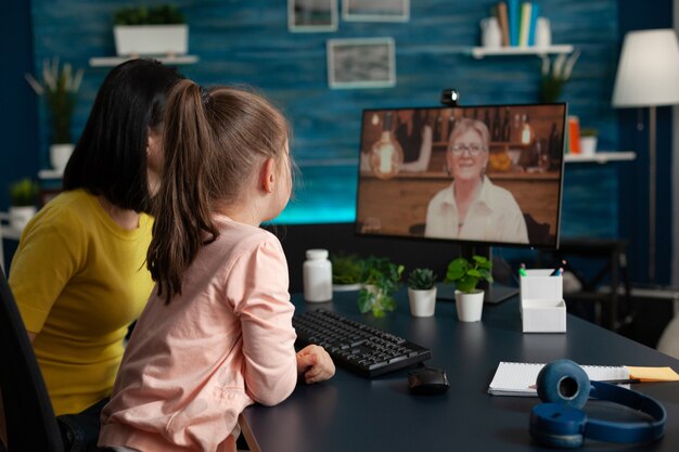 Parent et petit enfant se réunissant avec grand-mère lors d'un appel vidéo