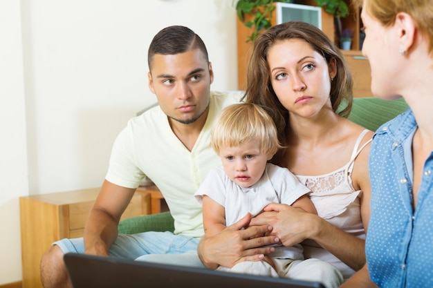 parents et bébé assis devant un travailleur social