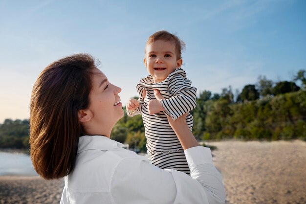 Parents avec un bébé sur la plage au coucher du soleil