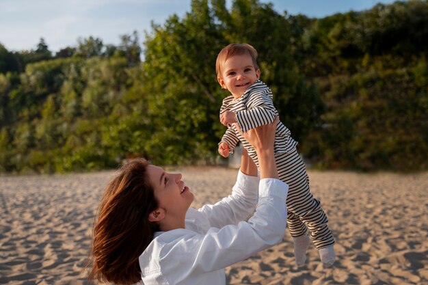 Parents avec un bébé sur la plage au coucher du soleil