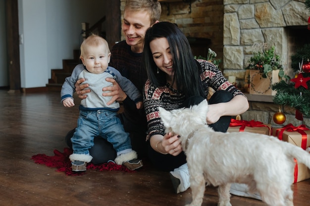 Les parents et un enfant jouant avec le chien