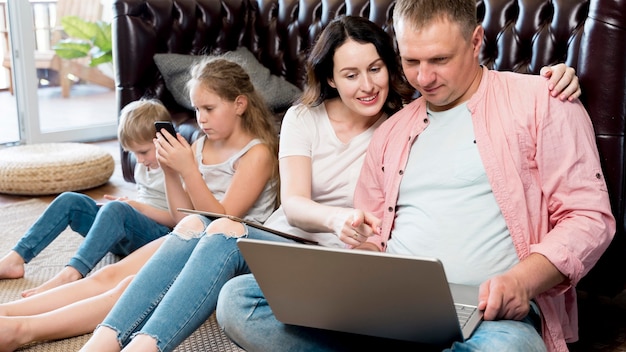 Parents et enfants à plan moyen avec des gadgets