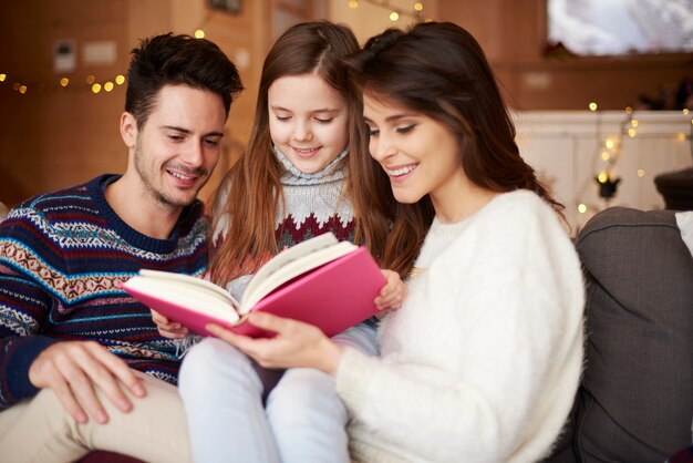 Parents avec fille lisant des contes de fées