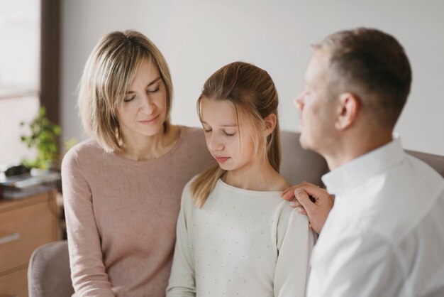 Parents et fille priant ensemble