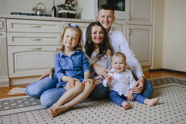 parents heureux assis sur le tapis avec les enfants