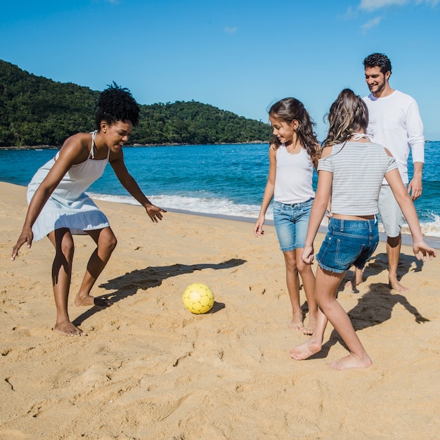 Photo gratuite les parents jouent avec leurs filles sur la plage