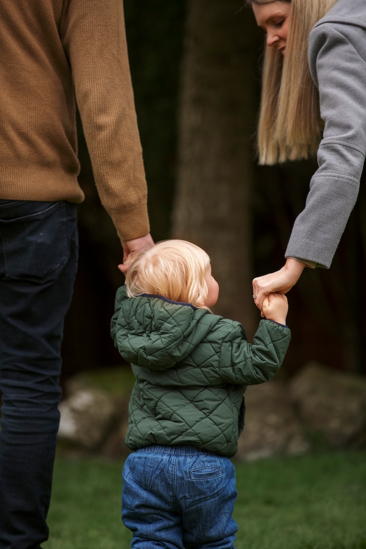 Photo gratuit parents marchant avec un enfant dans la nature