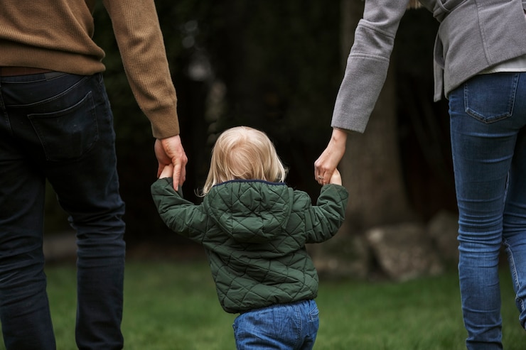 Photo gratuit parents marchant avec un enfant dans le parc