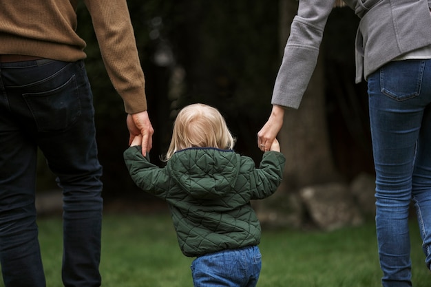 Parents marchant avec un enfant dans le parc