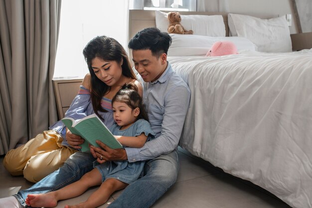 Parents de tir moyen et fille avec livre