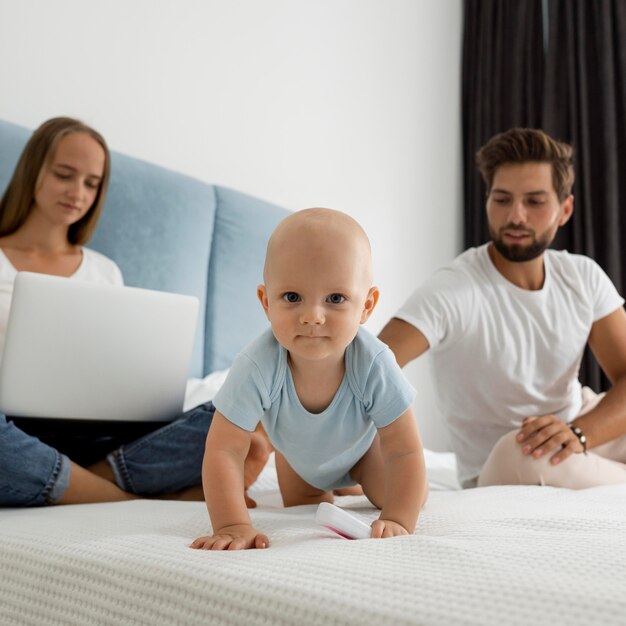 Les parents travaillant sur un ordinateur portable à la maison pendant la quarantaine avec enfant