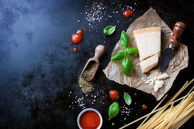 Photo gratuite parmesan recette de pâtes avec un morceau de fromage et de pâtes crues et d'autres ingrédients