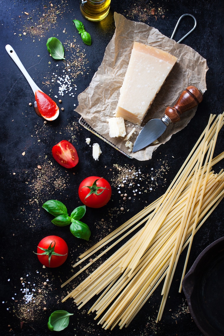 Photo gratuit parmesan recette de pâtes avec un morceau de fromage et de pâtes crues et d'autres ingrédients