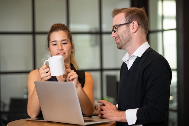 Partenaires d&#39;affaires décontractés discutant et travaillant à la table du café.