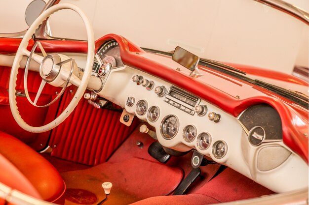 Partie avant de l'intérieur rouge d'une voiture, y compris le volant blanc