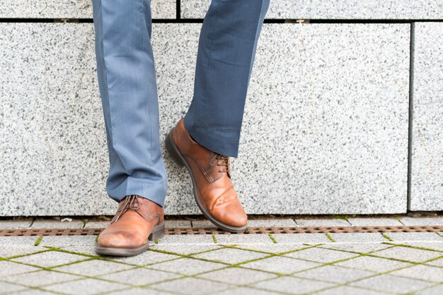 Partie d&#39;homme d&#39;affaires appuyé contre le mur